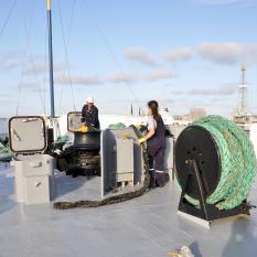 The bosun and third mate tidy up the lines.