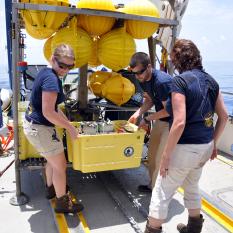 Sarah and Sam bring the first box into the ship's wet lab. 