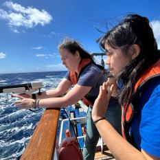 Two women lean over the rail of Nautilus