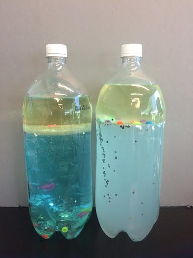 Side by side bottles with floating beads show differences between fresh and salt water