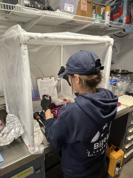 Student pivots in the wet lab standing at a tool bench